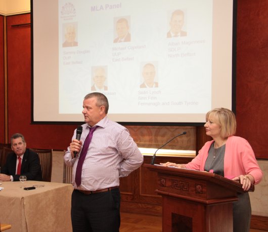 Alban Maginness MLA and BBC Political Correspondent Martina Purdy look on as Michael Copeland MLA takes questions from the floor.