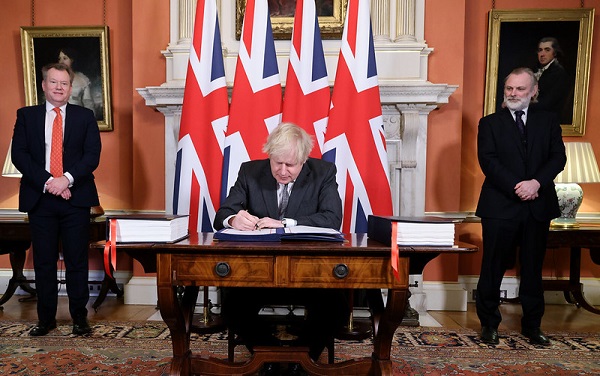 David Frost (left) watches as Prime Minister Boris Johnson signs the EU-UK Trade agreement | Source: Number 10/UK Prime Minister