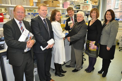 Members of the Northern Ireland Assembly Committee for Employment and Learning talk to a researcher on a visit to the Queen's University of Belfast's Centre for Cancer Research and Cell Biology. 