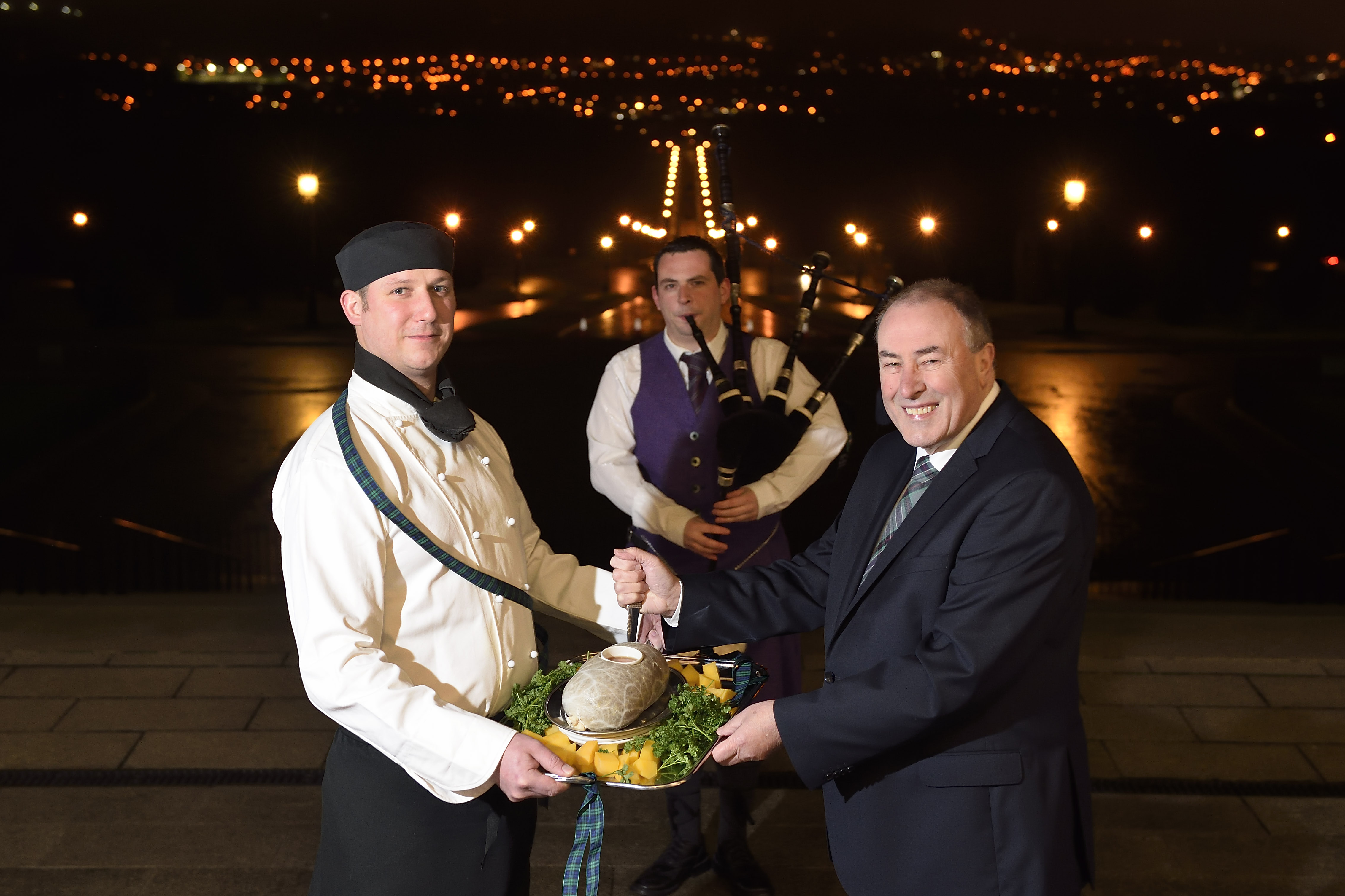 The Speaker of the Assembly, Mitchel McLaughlin MLA, pictured with Piper Darren Milligan and chef, Ashley McMahon presenting the haggis, at the first official Burns Night celebration in Parliament Buildings. The celebration of Scotland’s national poet, Robert Burns, took place in the Great Hall. Picture: Michael Cooper