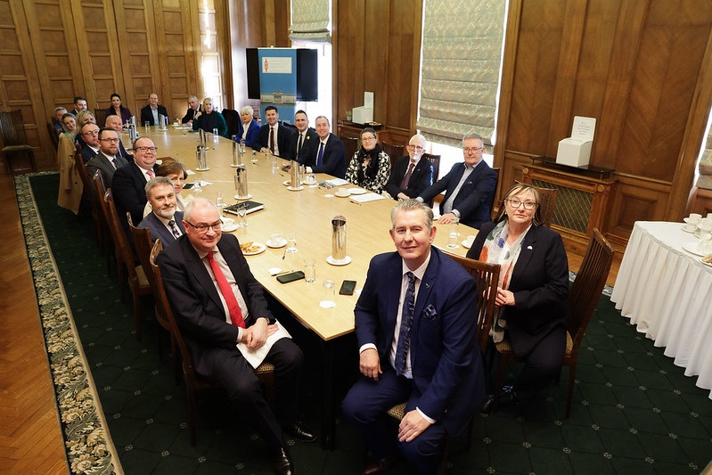 Members of the Commonwealth Parliamentary Association Northern Ireland branch turn to face the camera for a group shot to mark their AGM on 5 March 2024. At the head of the table is Assembly Speaker, Edwin Poots.