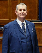 Speaker Edwin Poots standing in front of the Speaker's table in the Assembly Chamber