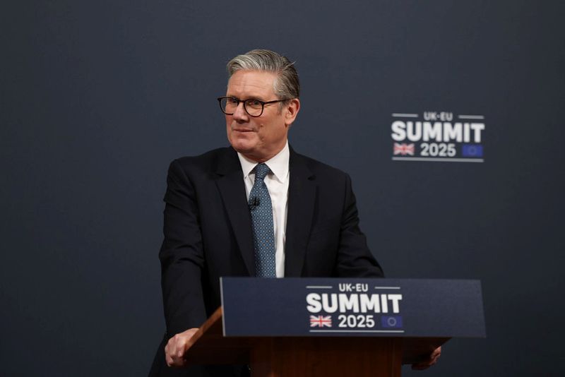 image shows the Prime Minister Keir Starmer standing at a podium with the words UK-EU Summit 2025 on the front. 