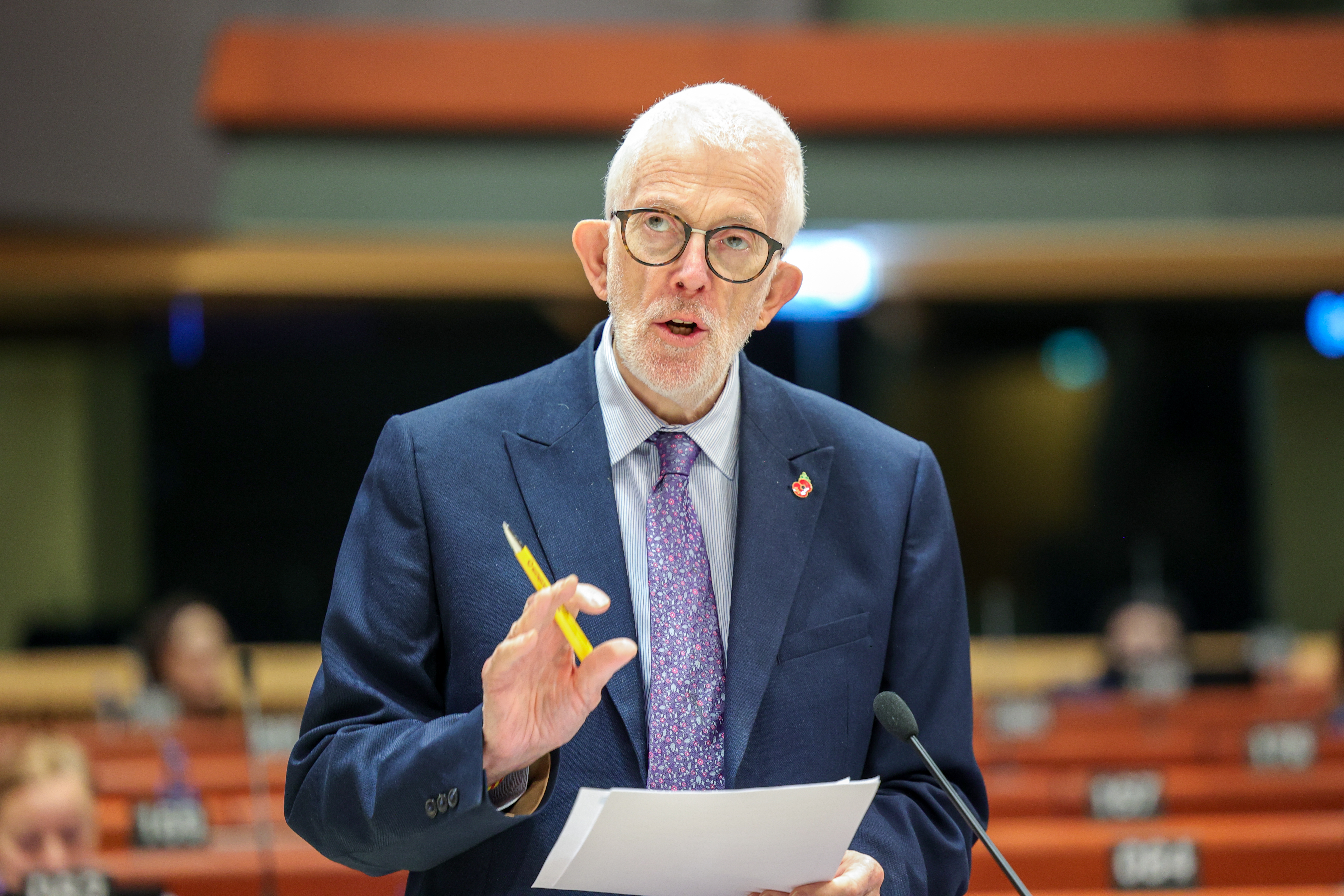 image shows Stewart Dickson MLA pictured speaking at a previous meeting of the Congress of Local and Regional Authorities. His left hand is raised and he is holding a pen, in his right hand he is holing sheets of paper.