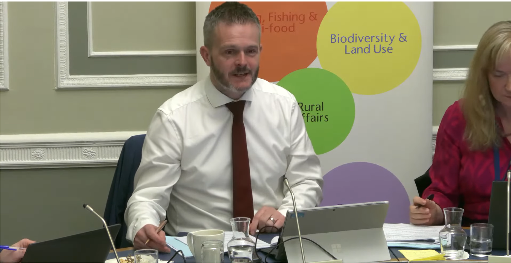 image shows the AERA Committee Chair in an Assembly Committee room as he takes evidence from departmental officials.  