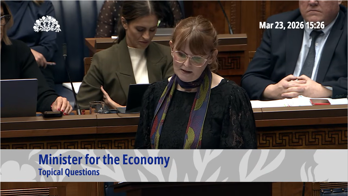image of the Economy Minister responding to oral questions in the Assembly Chamber. 