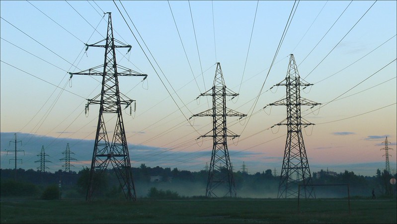 image shows three electricity pylons with overhead electric cabling