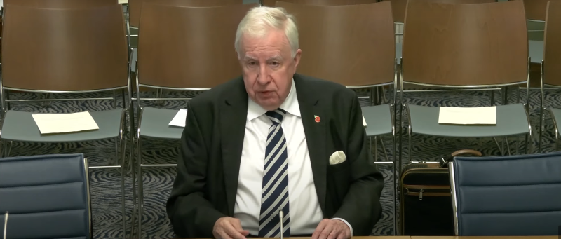 Lord Murphy seated in a Committee room in Parliament Buildings as he gives evidence to the Economy Committee.