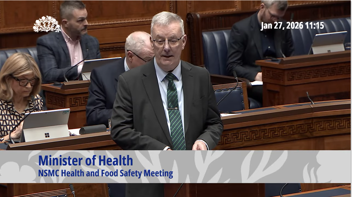 image shows the Health Minister making a statement in the Assembly Chamber. 