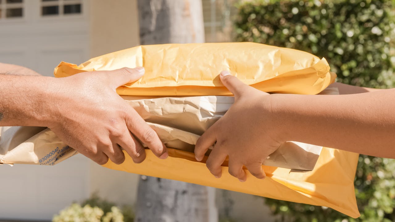 image shows the hands of two people exchanging small parcels 