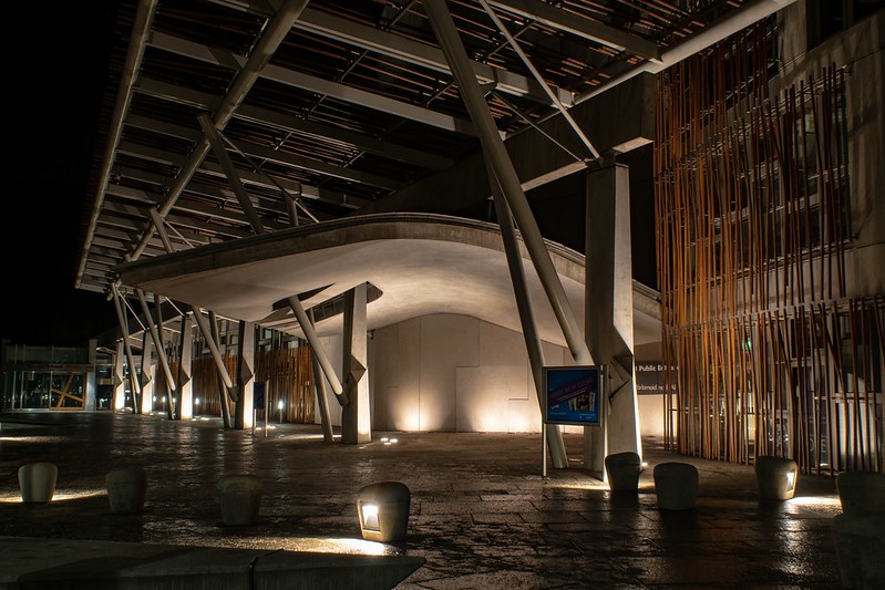 image shows the front of the Scottish Parliament Building at night. 
