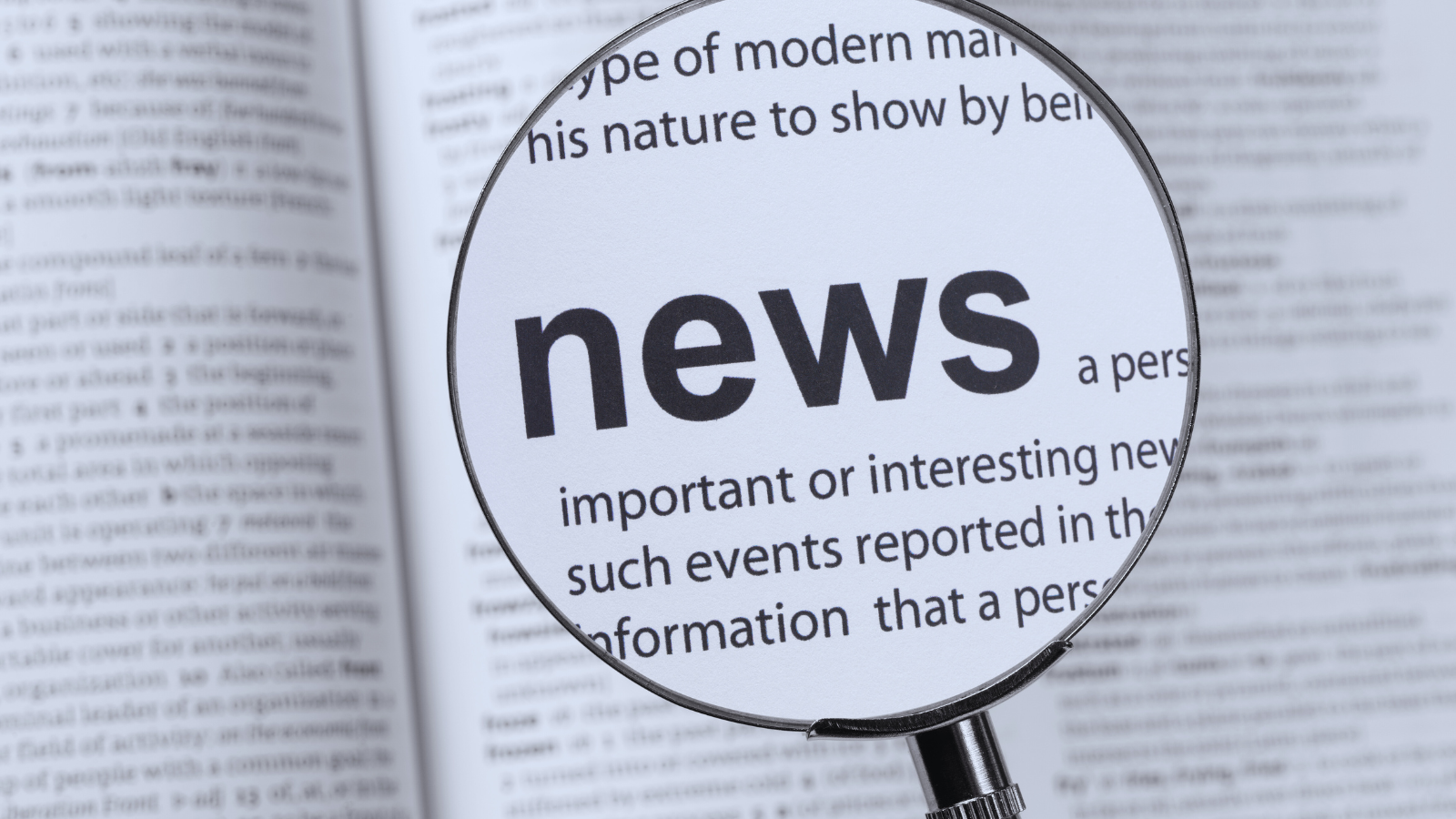 magnifying glass hovering over a dictionary page with the word news magnified in bold print