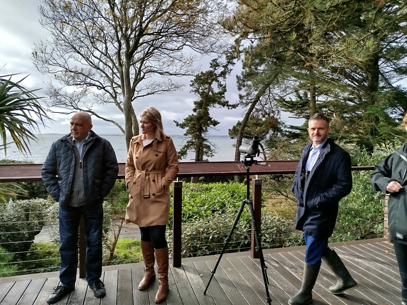 Members of the Committee, (left to right) John Blair MLA, Nicola Brogan MLA and Robbie Butler MLA during their tour of the Mount Stewart Estate. They appear to be on a viewing deck with a microscope looking out onto the estate and providing the perfect spot to look at the wildlife.