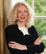 Clerk Chief Executive to the Assembly, Leslie Hogg, standing in front of a window in her office.