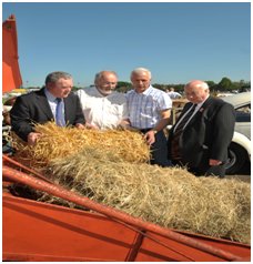 (Members being instructed in the use of a baling machine) 