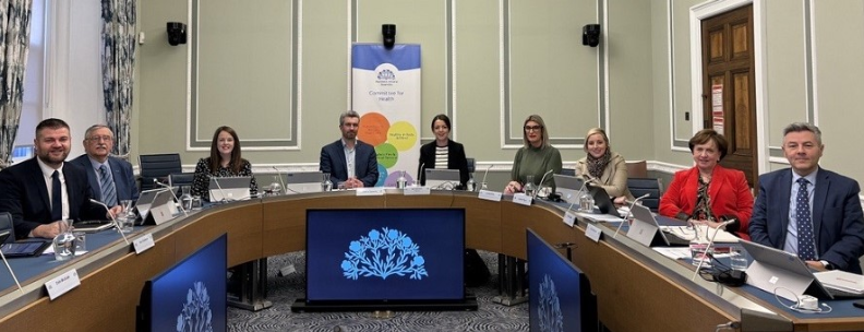 Members of the Health Committee sitting around a table in a committee room of Parliament Buildings