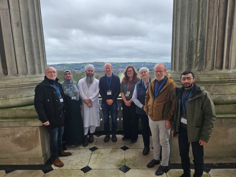 Assembly Explained Workshop participants pose on the balcony on the first floor of Parliament Buildings, with the Stormont Estate visible in the background.