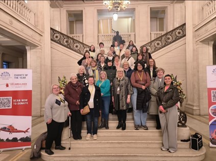 Attendees of an Assembly Workshop pose on the steps in the Great Hall in front of the statue of Lord Craigavon.