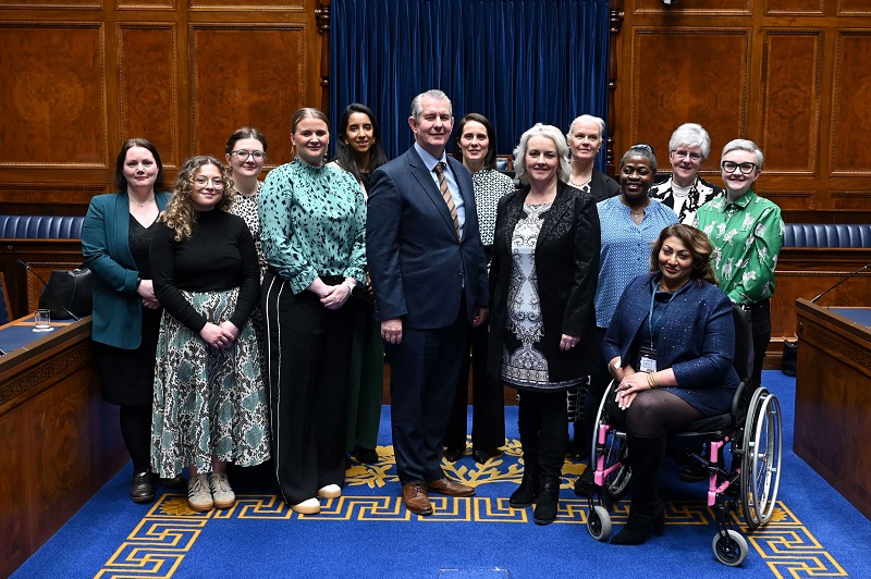 Speaker Edwin Poots poses in front of the Speaker's desk in the Assembly Chamber with Junior Ministers Aisling O'Reilly (left) and Pam Cameron (right) with attendees of the Women's Parliament